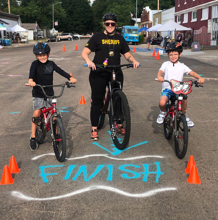 Washington County Sheriff's Officer Ash Judkins, center, helped with the bike safety obstacle course.