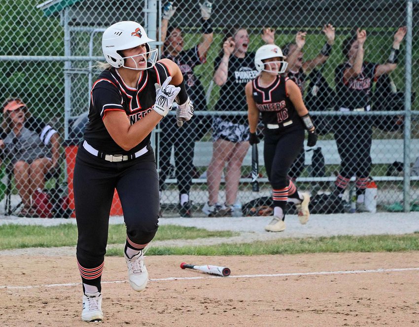 The Pioneers' Kaitlyn Welchert, left, races to first base as her dugout celebrates a run-scoring hit Thursday in Fort Calhoun.