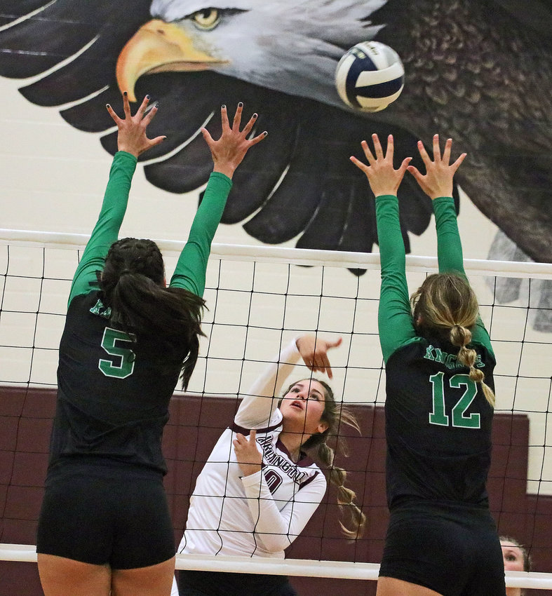 Eagles freshman Valeria Carvajal, middle, spikes the ball between Fremont Bergan's Paige Frickenstein, left, and Linden Nosal on Tuesday at Arlington High School.