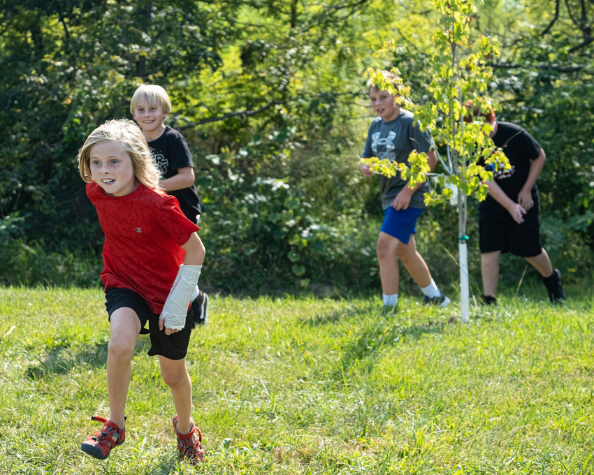 The Arbor Park running club follows along the mile long course through trees during one of its after-school sessions on Sept. 13.