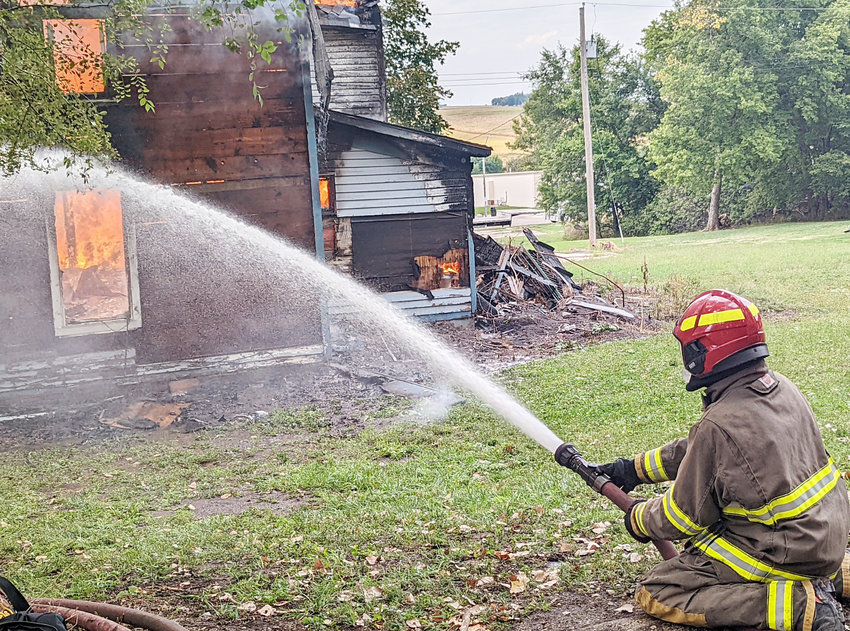With this much on fire the house will be coming down, but this firefighter is doing what he can to control the fire the way they want it.