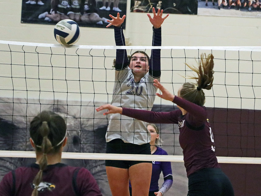 Blair sophomore Taylor Mostek, middle, gets a piece of Lizzie Meyer's spike Saturday at Arlington High School. The Bears won the tournament match with the Eagles, 2-0.