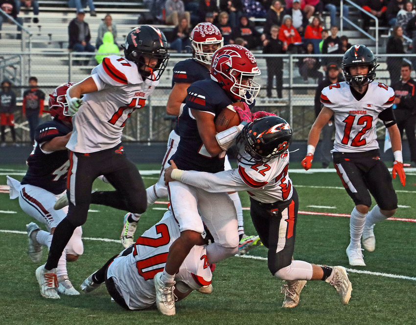 Fort Calhoun defenders Avery Quinlan (17), from left, Tyler DeMilt (20), Levi Lasher (22) and AJ Duros (12) swarm to a Trojans ball carrier Friday at Platteview High School.
