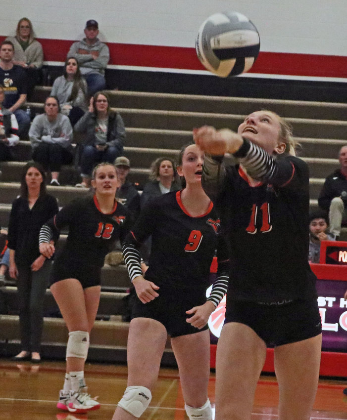 Fort Calhoun senior Olivia Quinlan reaches for the ball as her teammates and coach watch Monday at Douglas County West.
