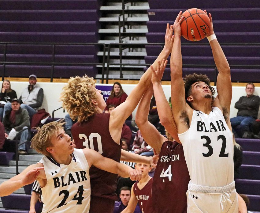 The Bears' J'Shawn Unger, right, pulls down a rebound from Arlington's Trent Koger (30) and Weston Wollberg (44) as Greyson Kay, left, does his part Monday at Blair High School.