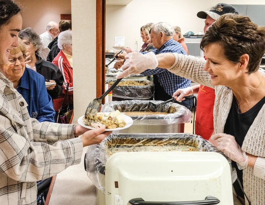 Volunteers from a number of local churches serve up Thanksgiving dinner Thursday at St. Francis Borgia Catholic Church.