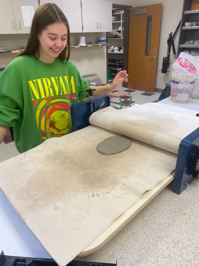 Arlington High School senior Emery McIntosh demonstrates how the pottery students are utilizing the new slab roller in class. The slab roller was one piece of equipment the art department received after being awarded two grants from the Fremont Area Community Foundation and Arlington Education Foundation.