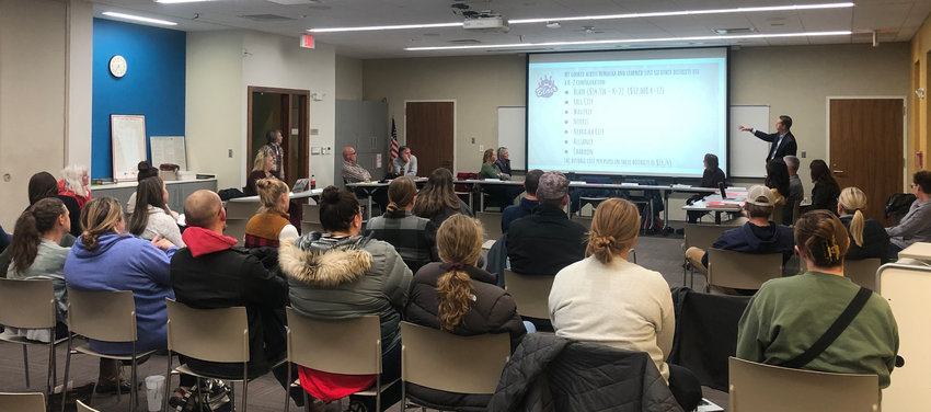 Blair Community Schools parents, teachers and administrators watch a presentation given by Supt. Dr. Randy Gilson during a public hearing regarding the potential reorganization of kindergarten through fifth grades at BCS on Dec. 8.