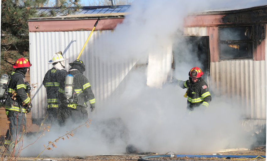 Heavy smoke pours out of a mobile home unit on Longview Drive as firefighters spray an active fire inside the unit. No one was injured in the Dec. 26 fire but a cat inside the home died.