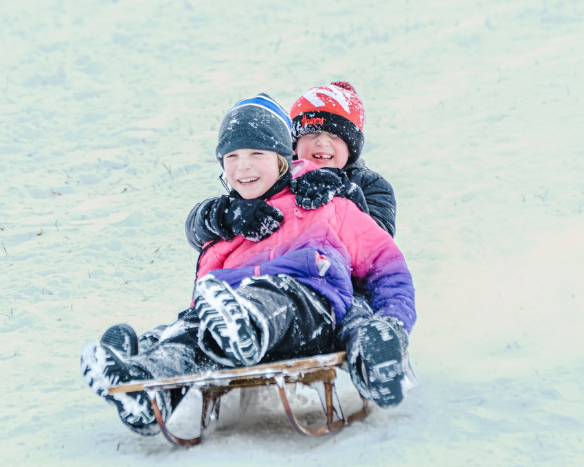 Skylar Bacon and Remington Cole take a ride on a runner sled down the hill at Steyer Park on Jan. 19. .
