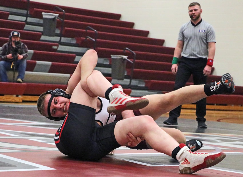 Eagles 182-pounder Tate Johannes, facing, finishes a takedown of Pender's Dylan Linkous on Thursday at Arlington High School.