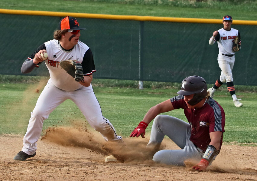 Fort Calhoun infielder Sam Halford, left, steps on second base and looks to first as Arlington's Grange Suhr slides in Tuesday at the Washington County Fairgrounds.