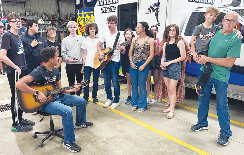 Avery Bryan, seated, and Owen Hineline, middle, lead the singing of some Christian choruses as the tornado approached Burt County on Friday evening.  The inner offices were soon filled as a place of shelter after this picture was taken.