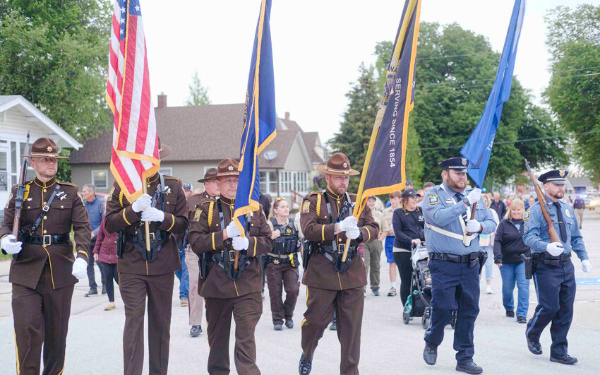 The Parade of Honor consisting of combined agency Honor Guards leads the Blue Light Vigil walk from the Blair Police Office to the Washington County Sheriff&rsquo;s Office Monday evening in celebration of National Peace Officers Memorial Week.