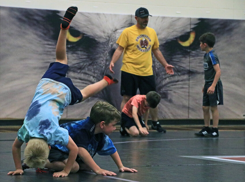Justin Koehler, 7, left, rolls over the top of Holden Kuhr, 6, during the Arlington Youth Wrestling camp at AHS. The two-day camp brought wrestlers in grades 2-6, high school wrestlers and coaches together for drills and mat work.