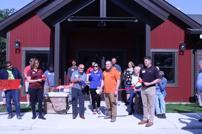 Dale Olson, third from left, cuts the ribbon at Camp Fontanelle Friday morning, officially opening the Olson Lodge, named after himself and his late wife, Fern.
