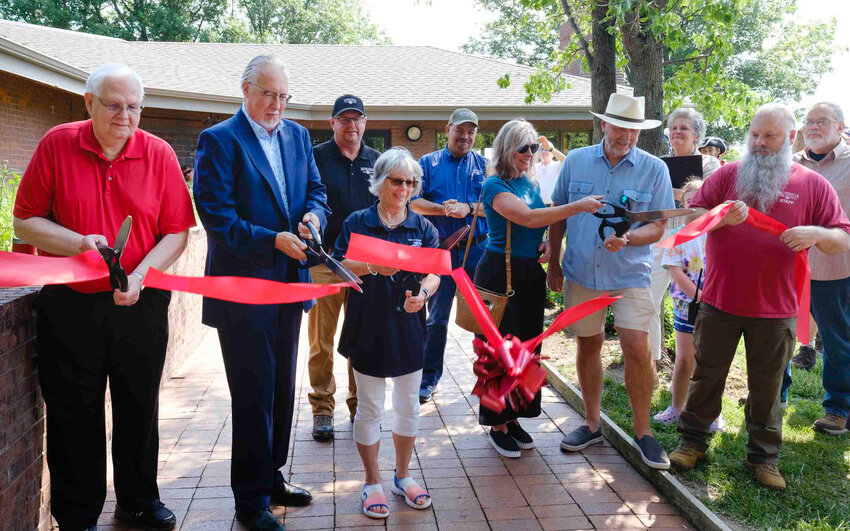 Fort Atkinson hosted a ribbon cutting at the Harold W. Andersen Visitor's Center Saturday morning. Pictured cutting the ribbon, from left, David Genoways, Clarence Mock, Susan Juza, Nancy Andersen, David Andersen and Jason Grof.