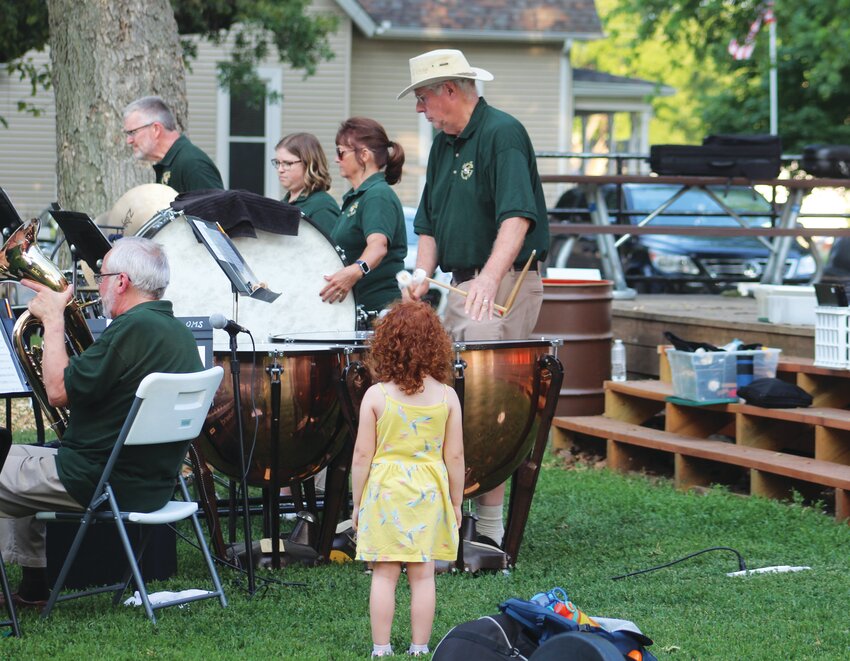 A young concertgoer stands fascinated by a Blair Area Community Band percussionist on Thursday at Lion's Park.