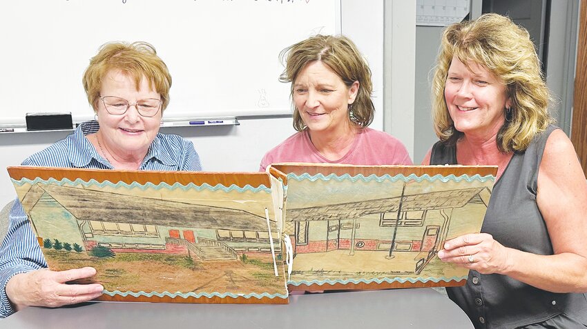 Looking over a scrapbook created for the former School District 81 are Rose Jaspersen, Sue Schroeder, and Sue Beckner.  A reunion is being planned for Aug. 13th for former students, teachers, and friends of District 81.