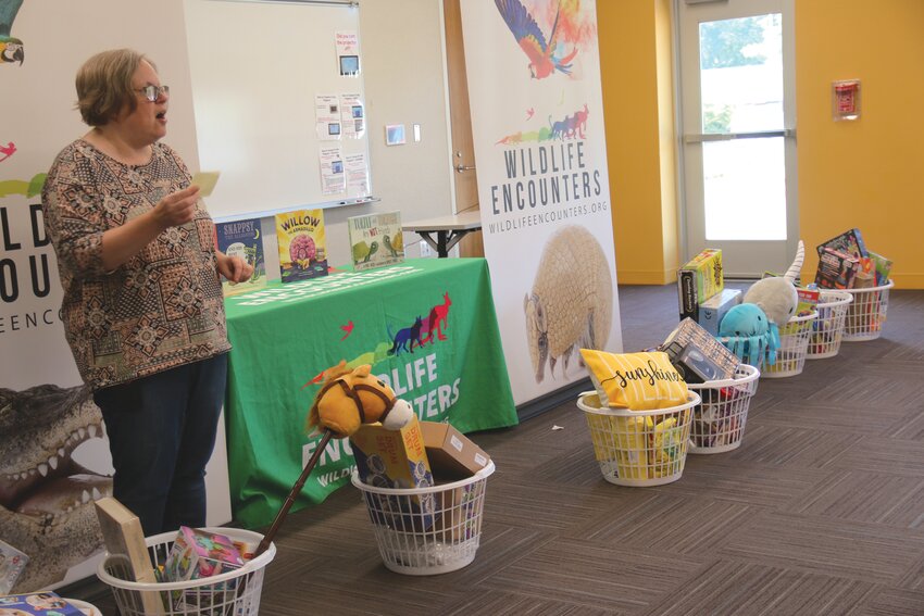 Wendy Lukert announces the winners of the grand prize drawing at the Blair Public Library's end of summer celebration on Friday. Each grand prize was a laundry basket full of toys, stuffed animals and more.