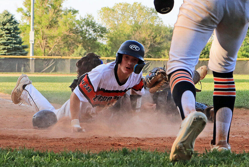 Fort Calhoun Senior Legion runner Eric Koterba, left, slides in safe Monday during the bottom of the seventh inning at Elkhorn Mount Michael. The run tied the B3 Area Tournament game with Wahoo, forcing extras during the Pioneers' season-ending loss.