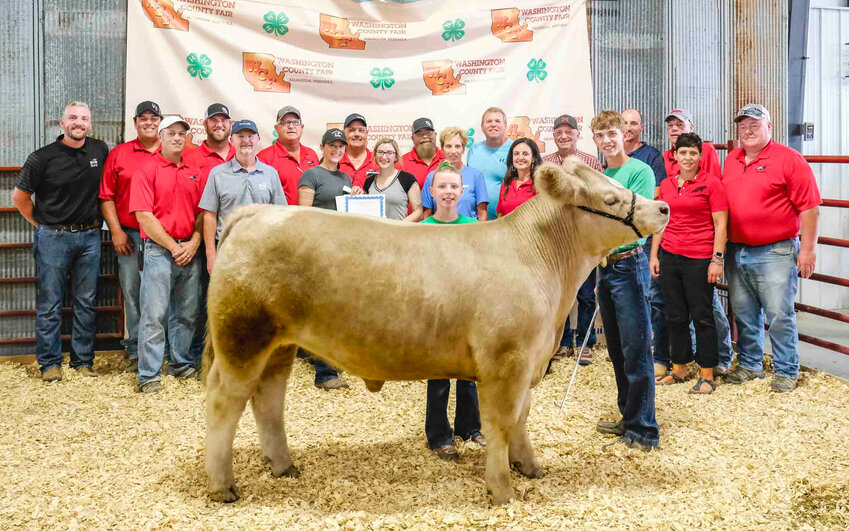 A steer purchased at the Washington County Fair auction will be donated and processed free-of-charge to provide more than 1,100 pounds of meat to the Washington County Food Bank.&nbsp;Pictured in the front is market heifer exhibitor Hadley Grabbe amd Tyler Thompson..