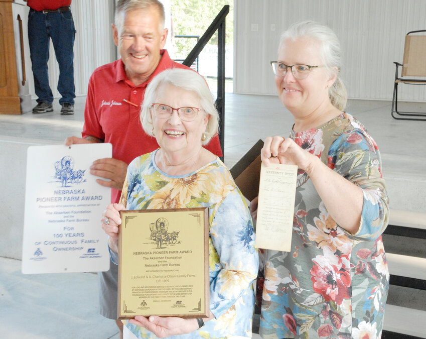 Johnnie Johnson, co-manager of the Burt County Fair, presents the Ak-Sar-Ben Pioneer Farm Family Award to Patricia French and Susan French Montgomery for 100 years of continuous family ownership.