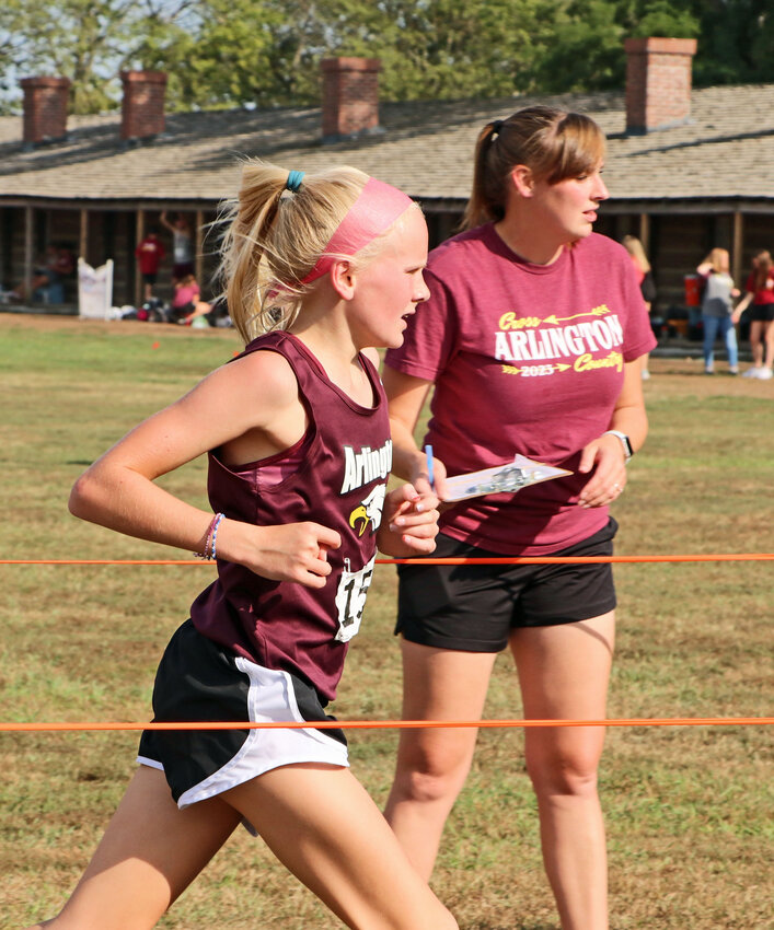 Arlington eighth-grader Grace Scheer, left, finishes a September race at Fort Atkinson as coach Helen Regier watches the clock. On Saturday, Scheer finished second in the open girls division of the Nebraska Junior High State XC Championships.