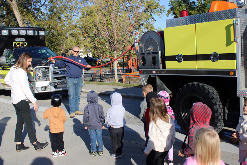 Joe Doyle shows Fort Calhoun preschool students equipment needed on a field truck to fight fires Tuesday morning.