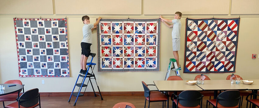 Cole Hoops (left), grandson of Judy and Matt Connealy, with his friend Hudson Moss performed community service by hanging eleven Quilts of Valor in Decatur.