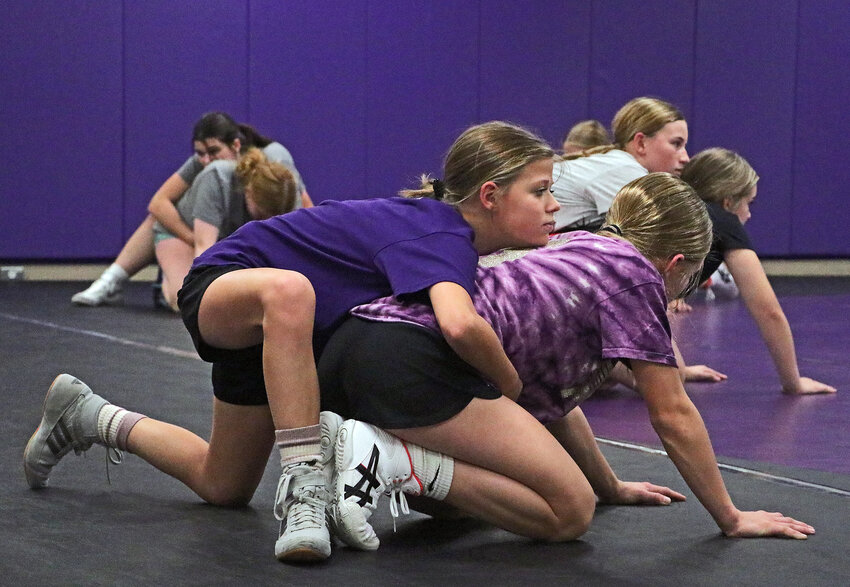 Kennedi Roan, top, gets ready to wrestle teammate Matilde Hall on Monday during an Otte Blair Middle School girls wrestling practice.
