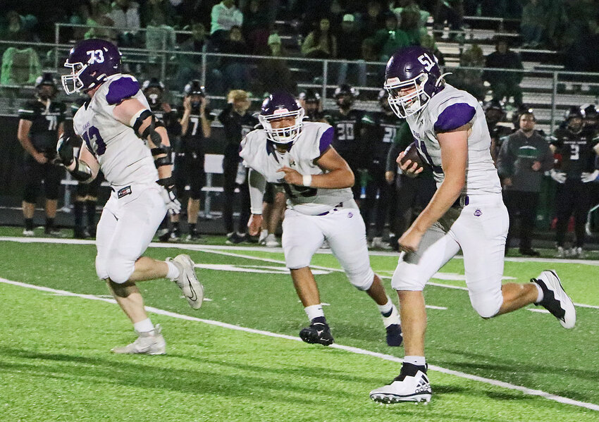 Blair junior Thomas Chikos, right, returns a fourth-quarter interception downfield with support from Gavin Ulrich, left, and Cornez Tucker on Friday at Omaha Skutt.