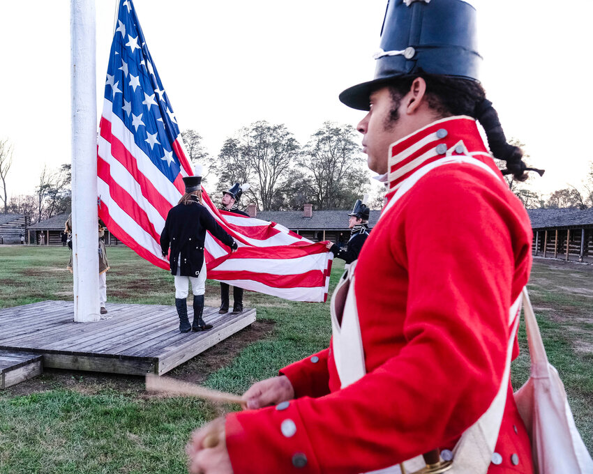 Flag detachment retires the colors at sunset as visitors arrive for the Living History Candlelight Tour Saturday at Fort Atkinson.
