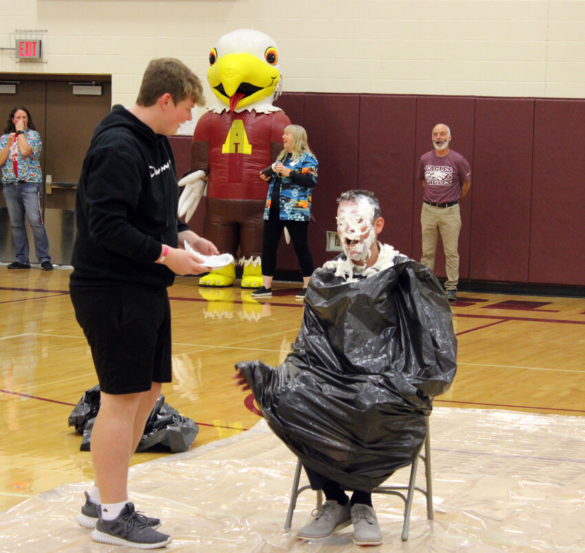 Arlington High School assistant principal was the recipient of two pies to the face Wednesday afternoon during an all-school pep rally to celebrate Arlington Public Schools collecting more than 2,000 pounds of food for the Washington County Food Pantry.