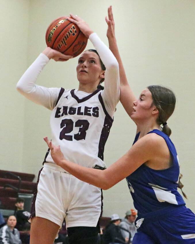 Eagles junior Britt Nielsen, left, makes a jump shot while fouled by Columbus Lakeview's Taylor Helms on Saturday at Arlington High School.