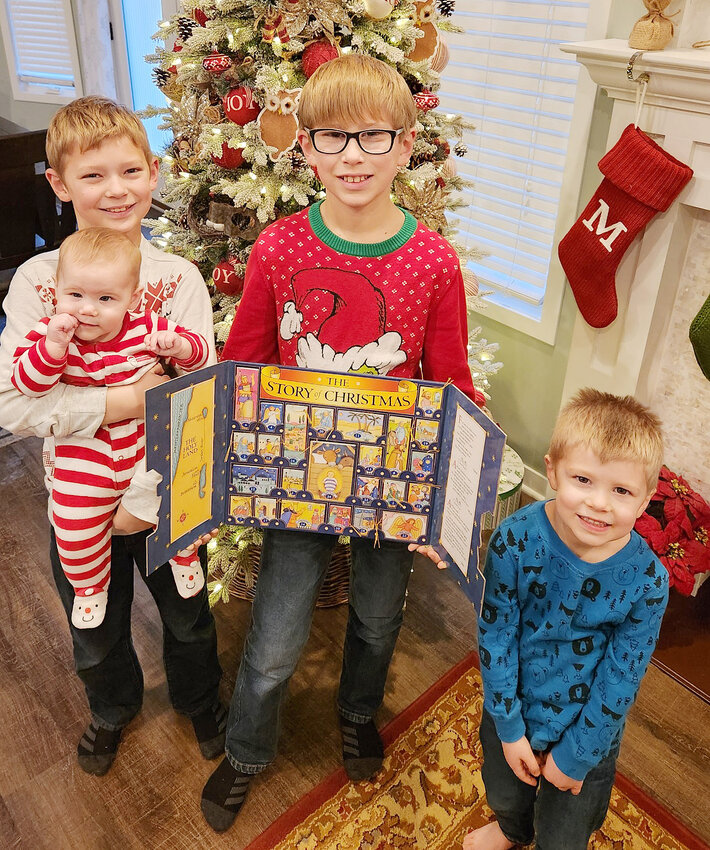 Brothers Liam Carr (11) and Landon Carr (9) look forward to reading the daily stories about Christmas each year to their younger siblings Lincoln (3) and Sharlotte (7 months).