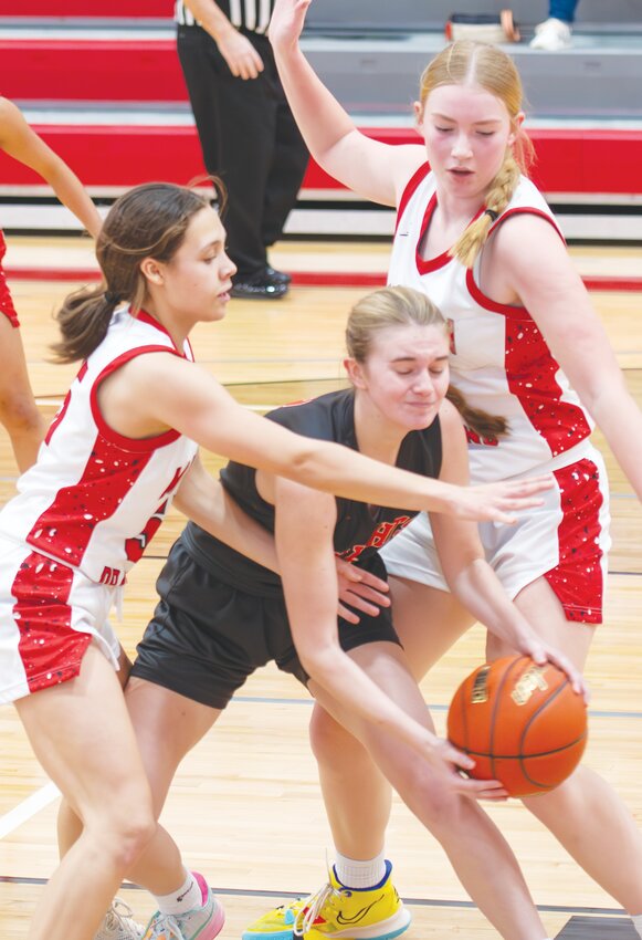 Staying strong against a stiff defense, Mia Thomsen finds away around the outstretched arms of the Madison defenders.
