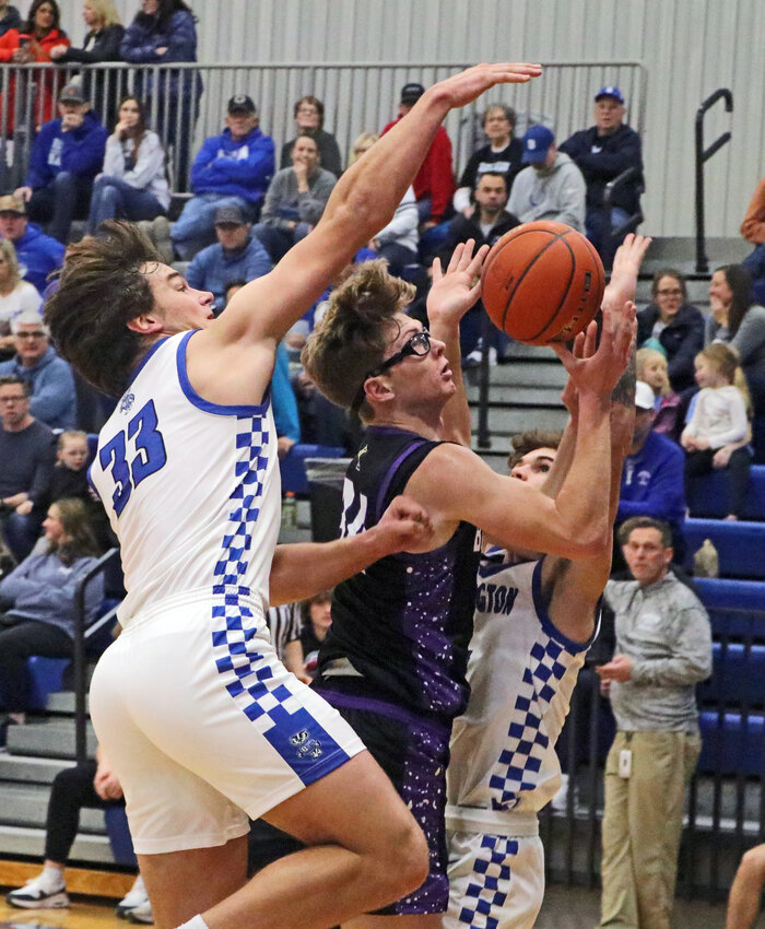 Blair sophomore Bo Meier, middle, is fouled in the paint Saturday at Bennington High School.