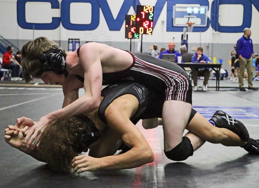 Arlington's Cameron Hancock, top, competes against a Cowboy on Friday at Boys Town.