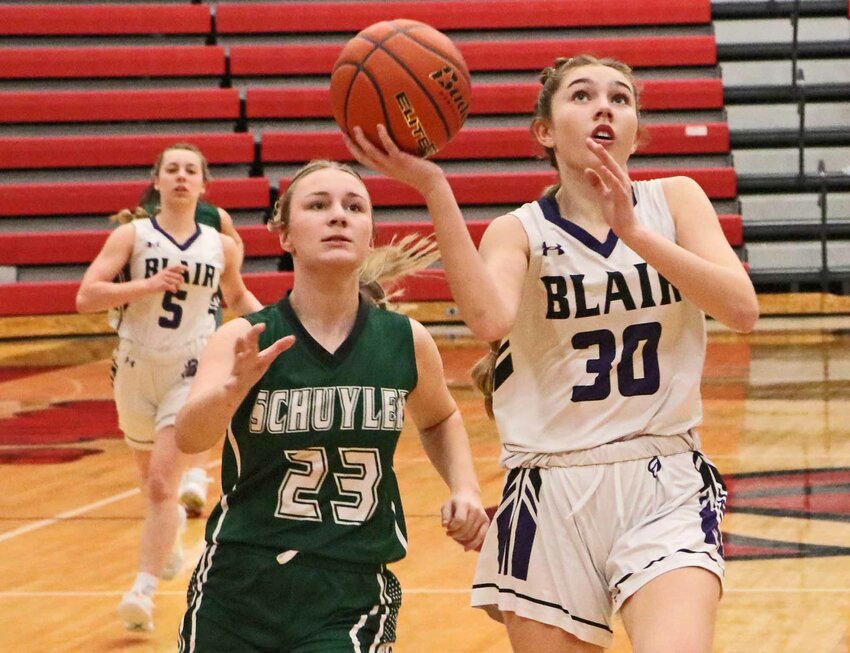 Blair freshman Gueryn Kay, right, scores a bucket in front of Schuyler's Addison Vavricek on Monday during the Class B-5 Subdistrict Tournament at South Sioux City High School.