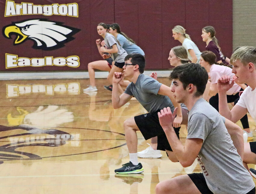 Track and field athletes go through warmups Tuesday at Arlington High School. The Eagles started practiced Monday under the direction of new head coach Kyle Buckingham.