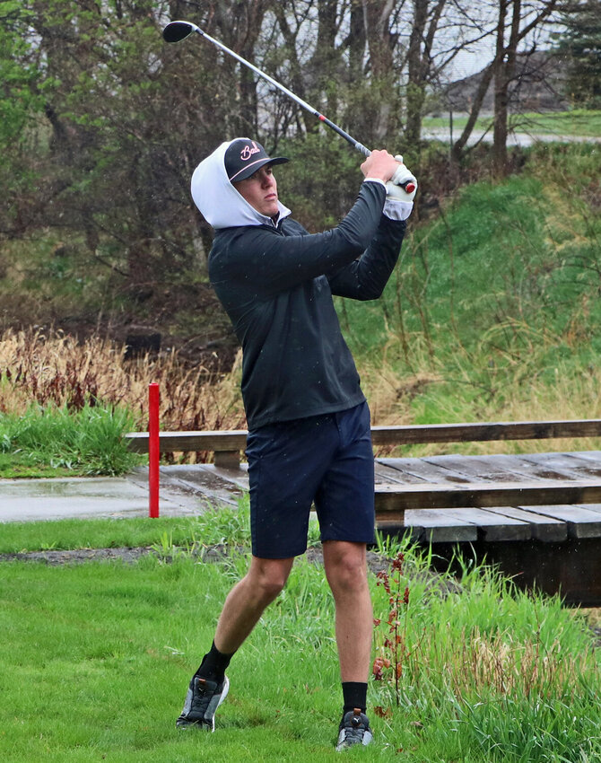 Arlington's Josh Hamre watches a shot through the rain during the 2023 season. The Eagle returns for his senior golf season this spring.