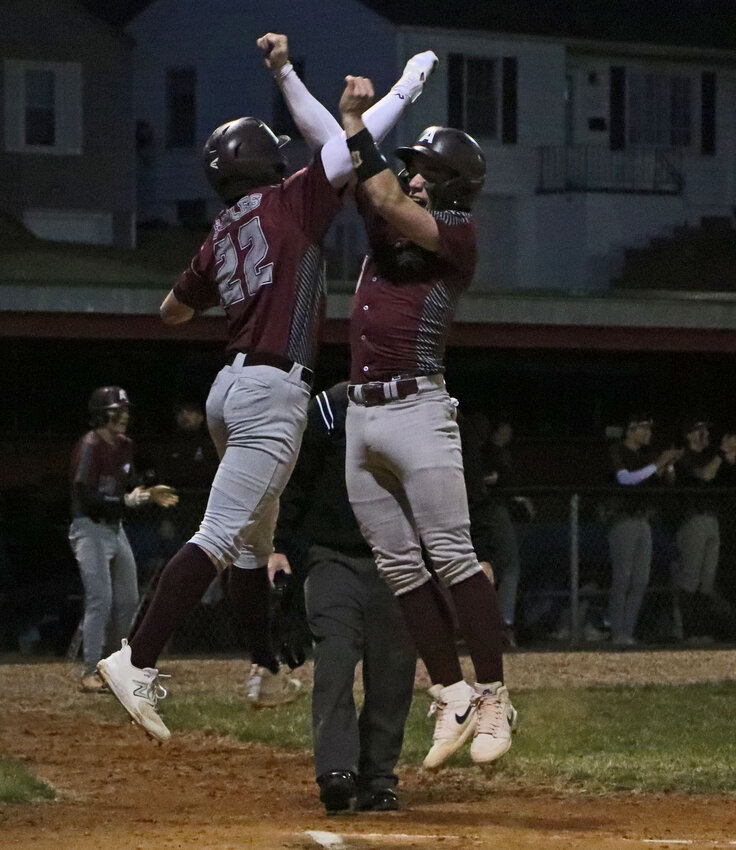 Arlington's Killian McIntosh, left, and Tim Halley celebrate scoring the first two runs of the season Friday on Blaine Vogt's double to centerfield in Ralston. The Eagles took a 6-0 first inning lead against Omaha Northwest.