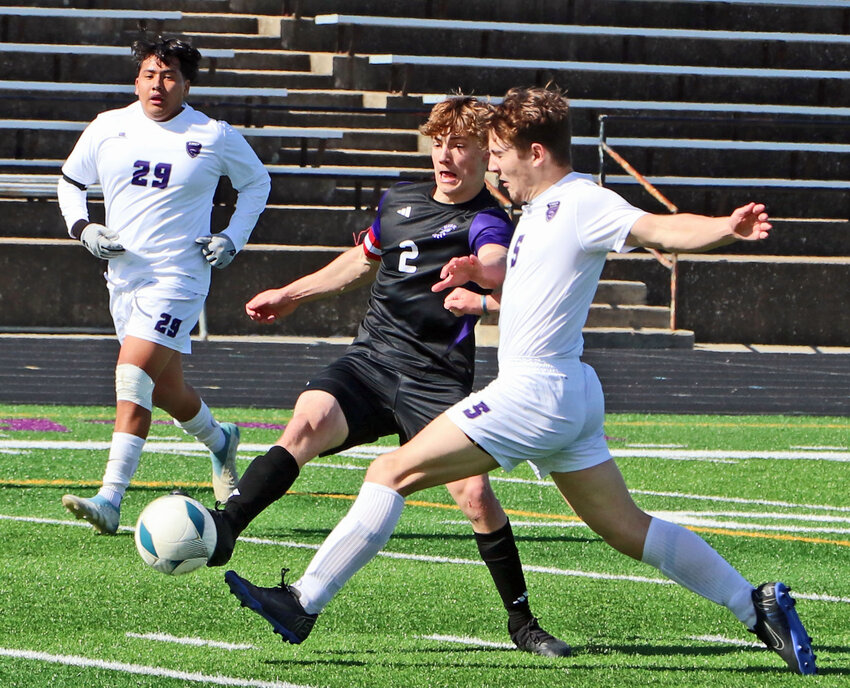 Blair senior Quinn Baedke, middle, lunges for the ball between Lincoln Northwest's Daniel Gibilisco, left, and Steven Frede on Saturday at Krantz Field.