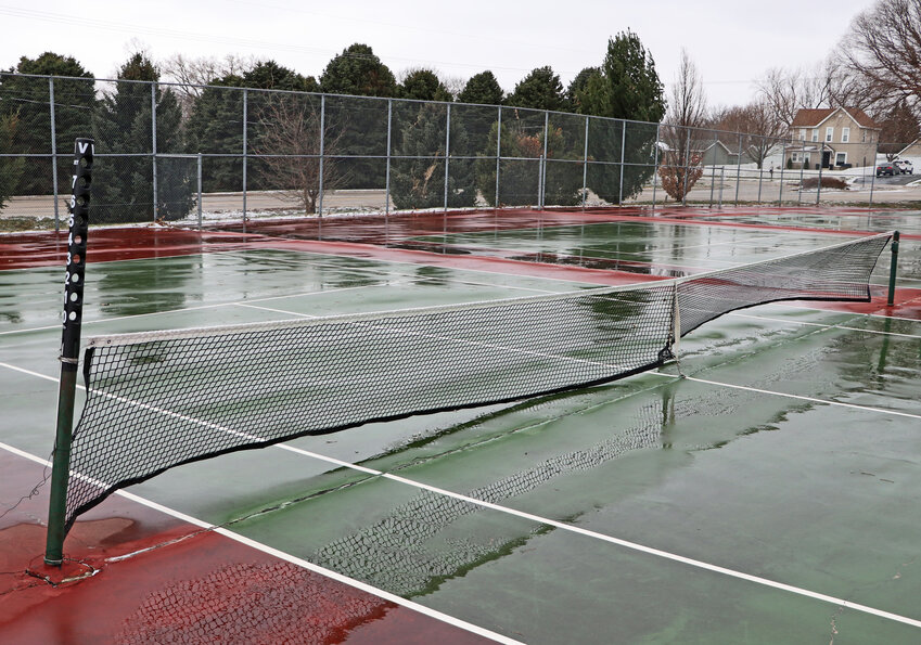 Puddles sit all over Blair High School's tennis courts at Stemmermann Park on Tuesday. Cold temperatures and a slight snow facilitated multiple high school sports postponements early this week.