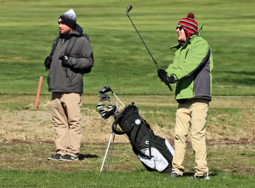 Fort Calhoun's Jayden Miller, right, watches his drive down the fairway alongside coach Dustin Humphrey on April 3 at The Pines in Valley.