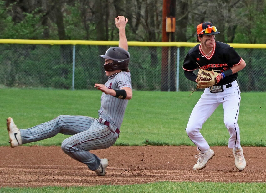 Arlington's Tim Halley, left, slides into third base as Pioneers infielder Sam Genoways gets ready to throw to first for an out Tuesday in Fort Calhoun.