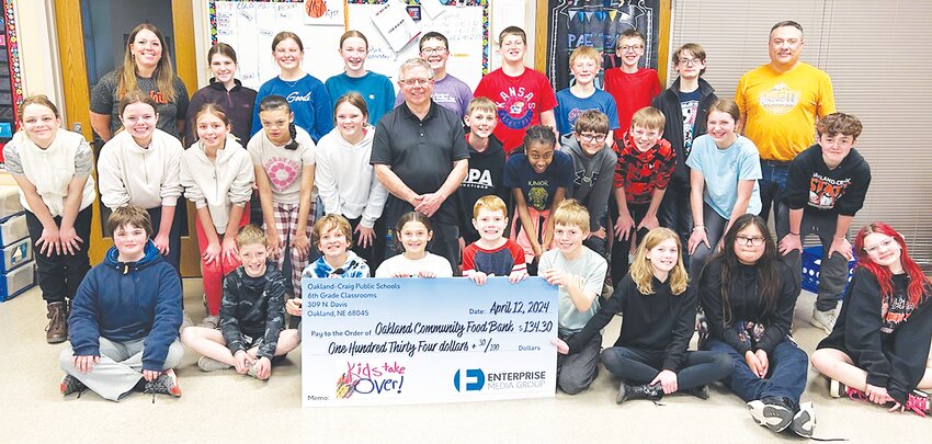 Pictured with the 6th-grade classrooms at Oakland-Craig is Cory Martin, board president of the Oakland Food Pantry.  The 6th Grade Class donated a portion of the proceeds from the Kids Take Over Design-n-ad project.  Their adverting creations were featured in last week