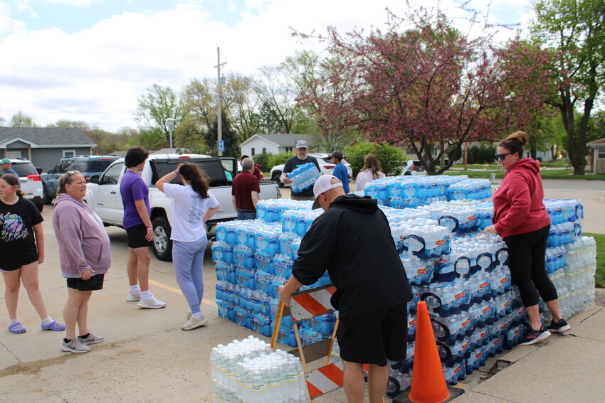Volunteers at First Lutheran Church-ELCA gather pallets of water bottles Saturday afternoon. The church was set up as a hub for those in need of supplies and packing material