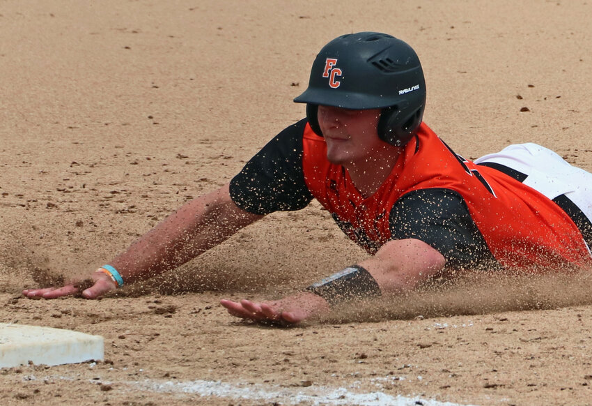 The Pioneers' Carter Christensen slides in safe at third base Saturday in Fort Calhoun. FCHS played as the away team, hosting Omaha Concordia after the Mustangs' field was determined too wet and unplayable.